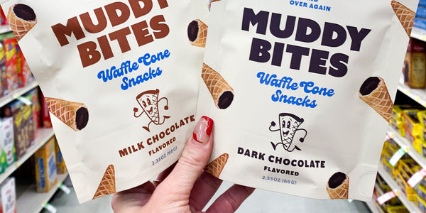 Milk chocolate and dark chocolate Muddy Bites waffle cone snacks held up in a retail store aisle